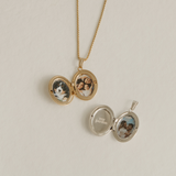 A gold and a silver locket open to show the inside engraving and photos.