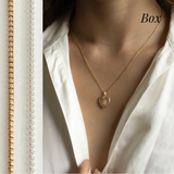 A gold heart locket on a gold box chain.