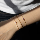 model wearing 3 different gold fill bracelets on wrist