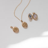 gold lockets on a white surface showing the outside and inside of the locket