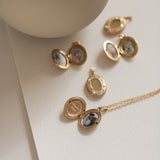 gold lockets displayed on a flat, white surface